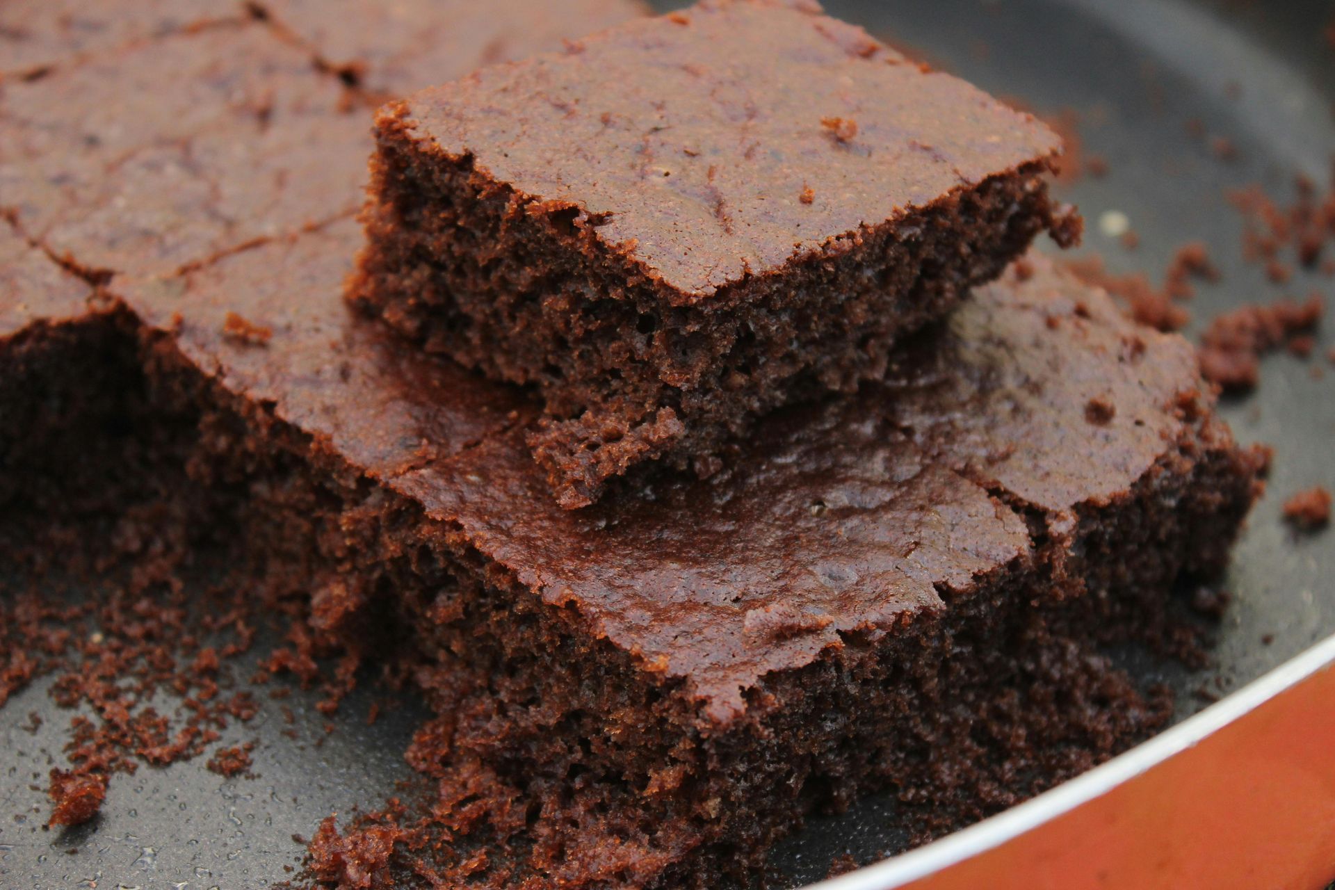 Overhead shot of freshly baked chocolate brownies, individual squares with a crackly top.