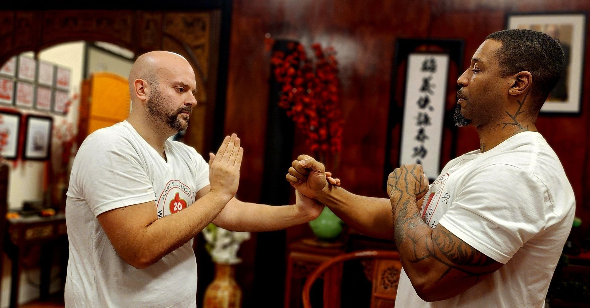 Two men are practicing martial arts in a room.