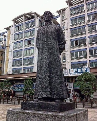 A statue of a man standing in front of a building
