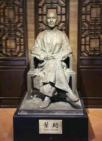 A statue of a man sitting in a chair with his arms crossed.