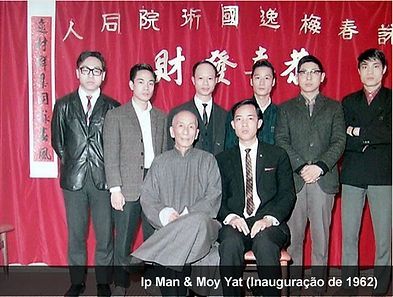 A group of men standing in front of a red curtain with chinese writing on it