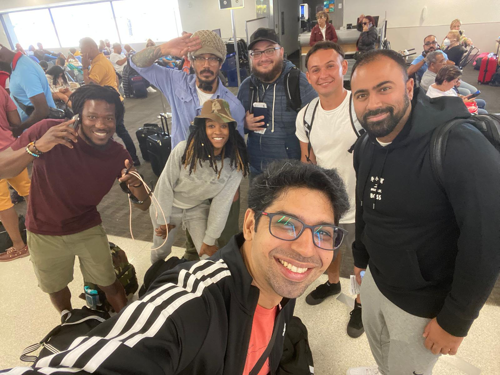 A group of people are posing for a picture at an airport.