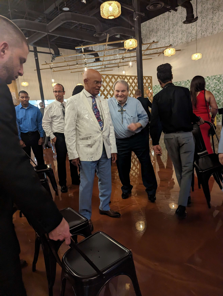 A group of men are standing in a room talking to each other