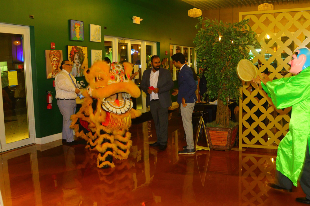 A group of people are standing around a lion statue in a room.