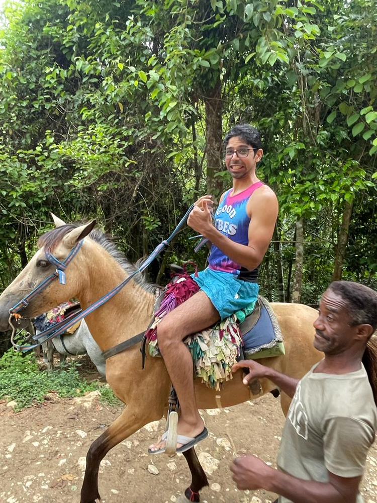 A man is riding a horse with a man standing next to him.