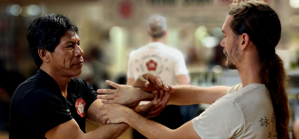 Two men are holding each other 's hands in a gym.