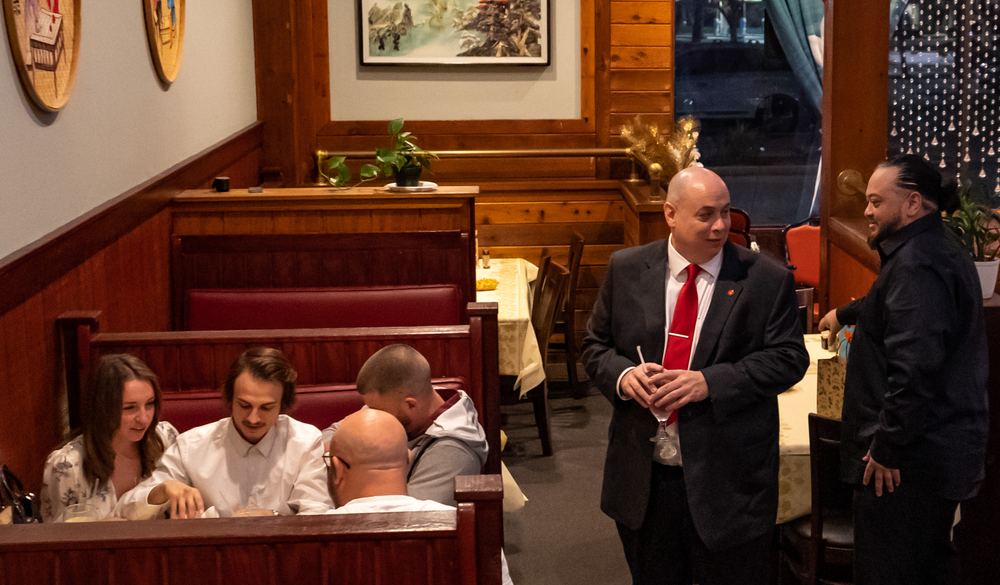 A group of people are sitting at tables in a restaurant.