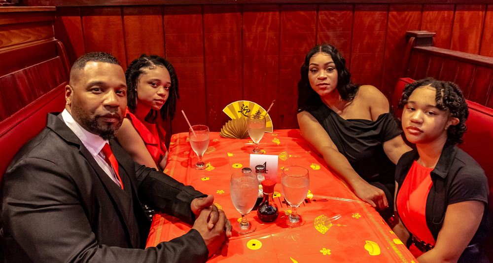 A man and three women are sitting at a table in a restaurant.