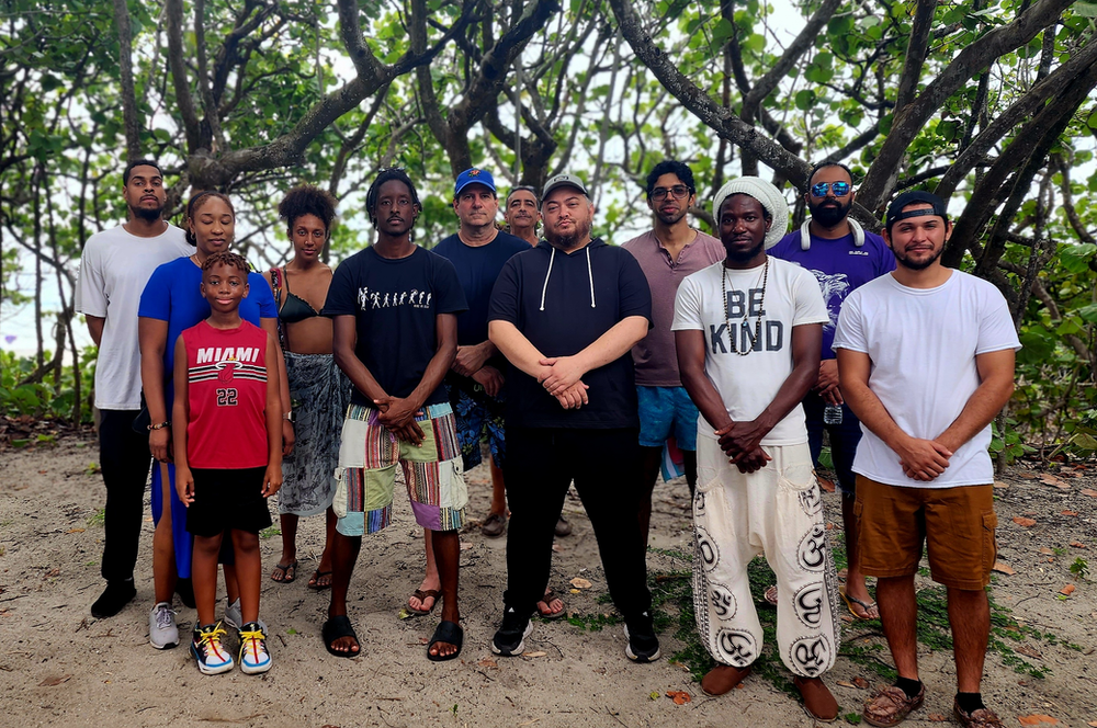 A group of people are posing for a picture and one of them is wearing a shirt that says be kind.