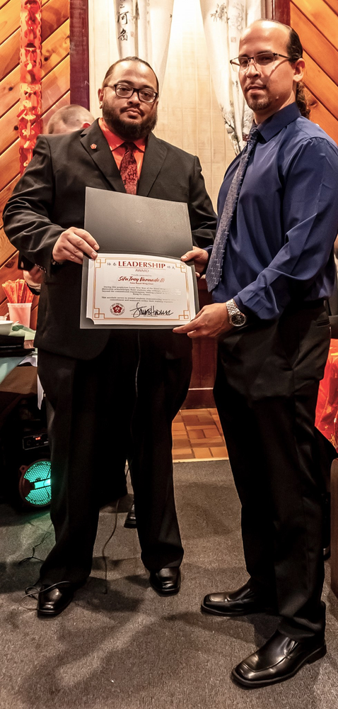 Two men are standing next to each other holding a certificate.