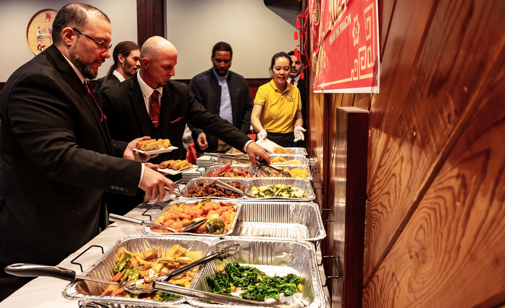 A group of people are standing at a buffet line.