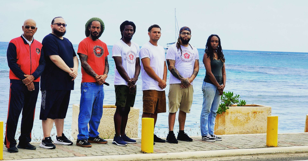 A group of people standing next to each other on a beach.