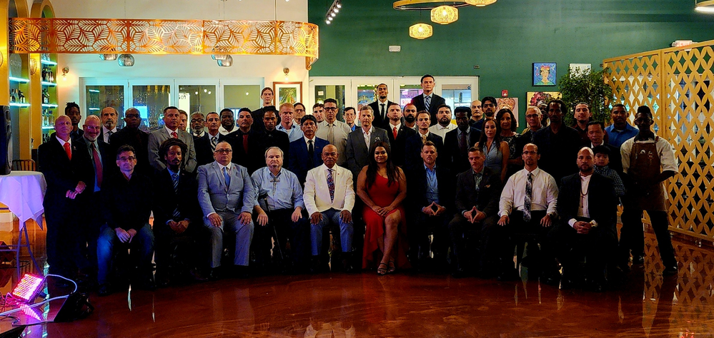 A large group of people are posing for a picture in a room.