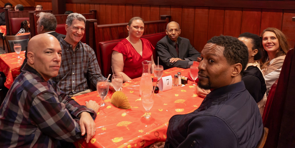 A group of people are sitting at a table in a restaurant.