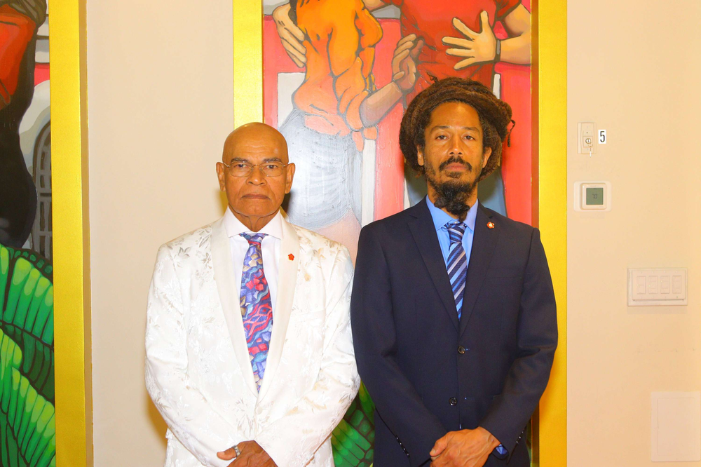 Two men in suits and ties are standing next to each other in front of a painting.