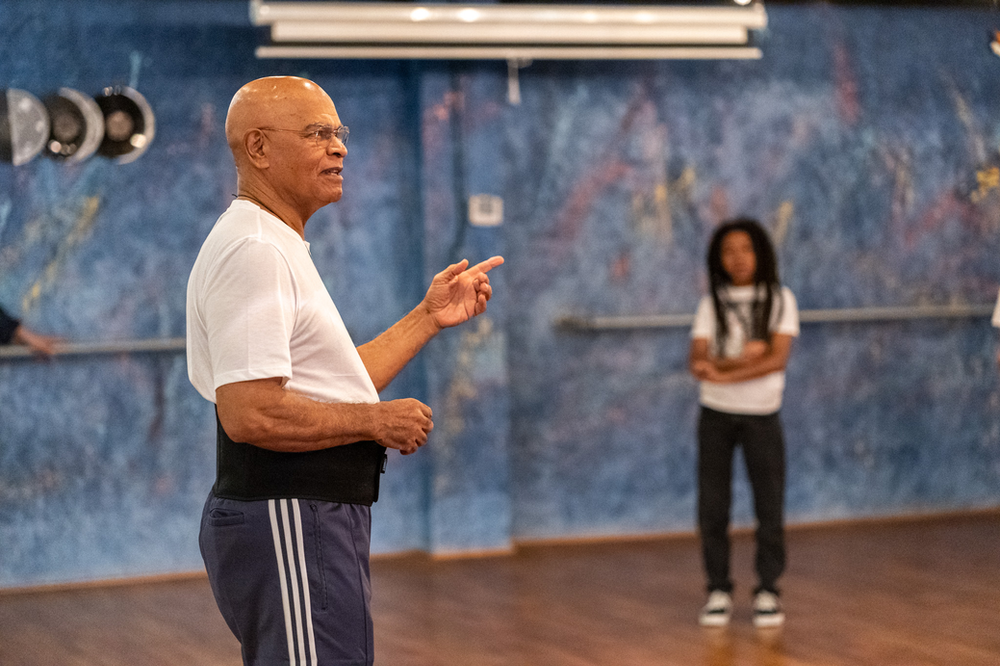 A man is pointing at a girl in a dance studio.