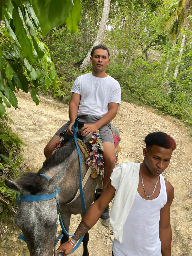 A man is riding a donkey on a dirt road.