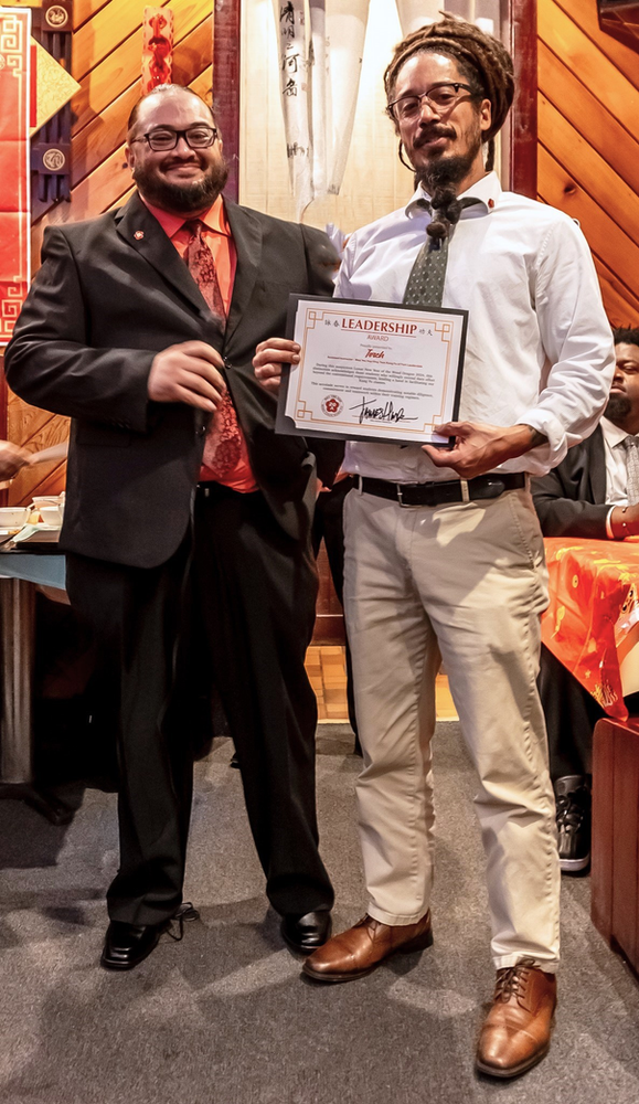 Two men are standing next to each other holding a certificate.