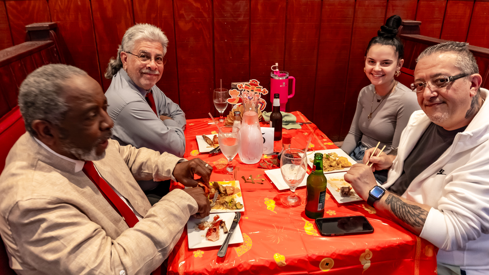 A group of people are sitting at a table eating food.