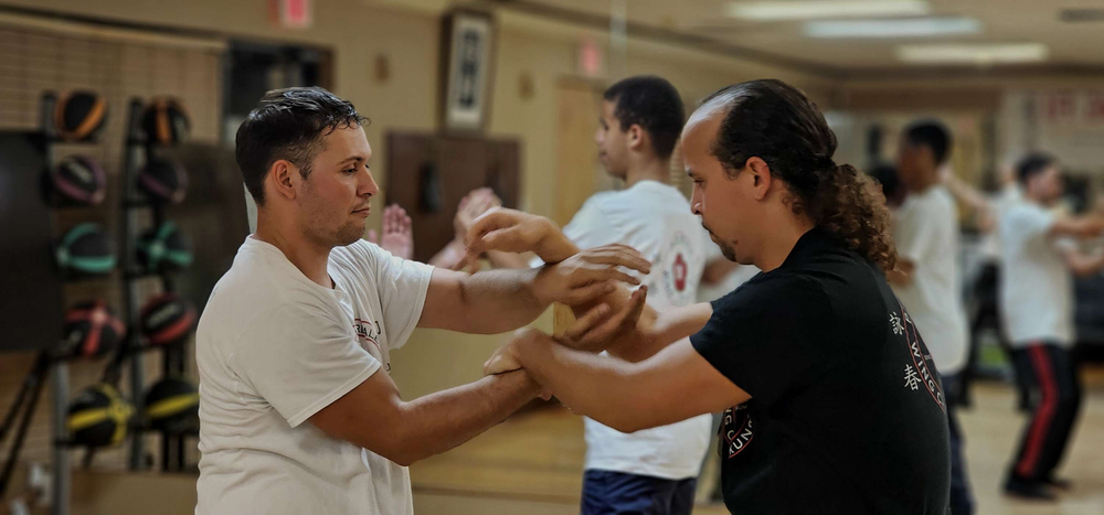 A group of men are practicing martial arts in a gym.