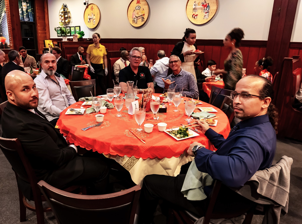 A group of men are sitting around a table in a restaurant.