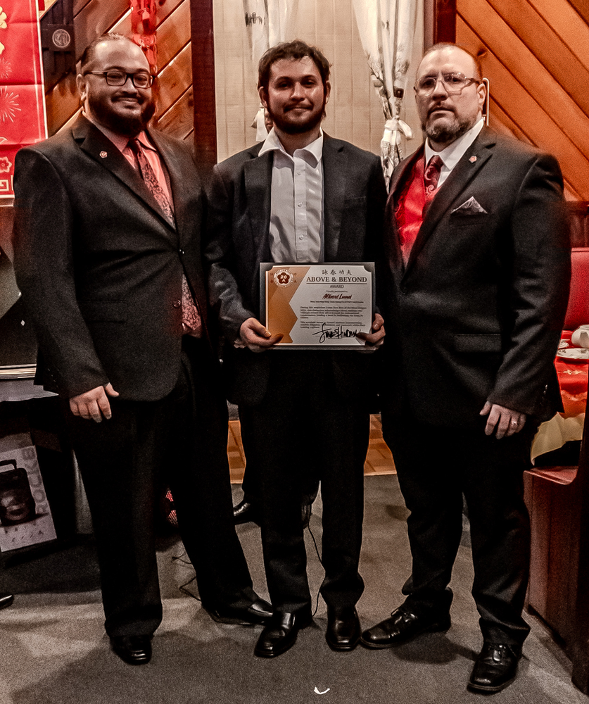 Three men in suits standing next to each other holding a certificate