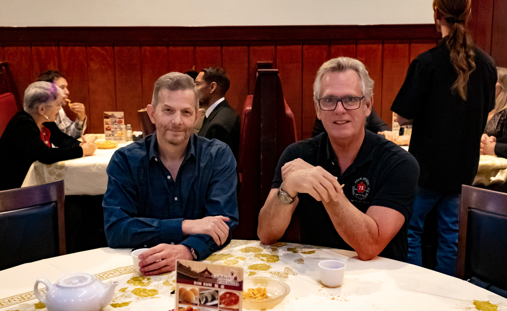 Two men are sitting at a table in a restaurant.