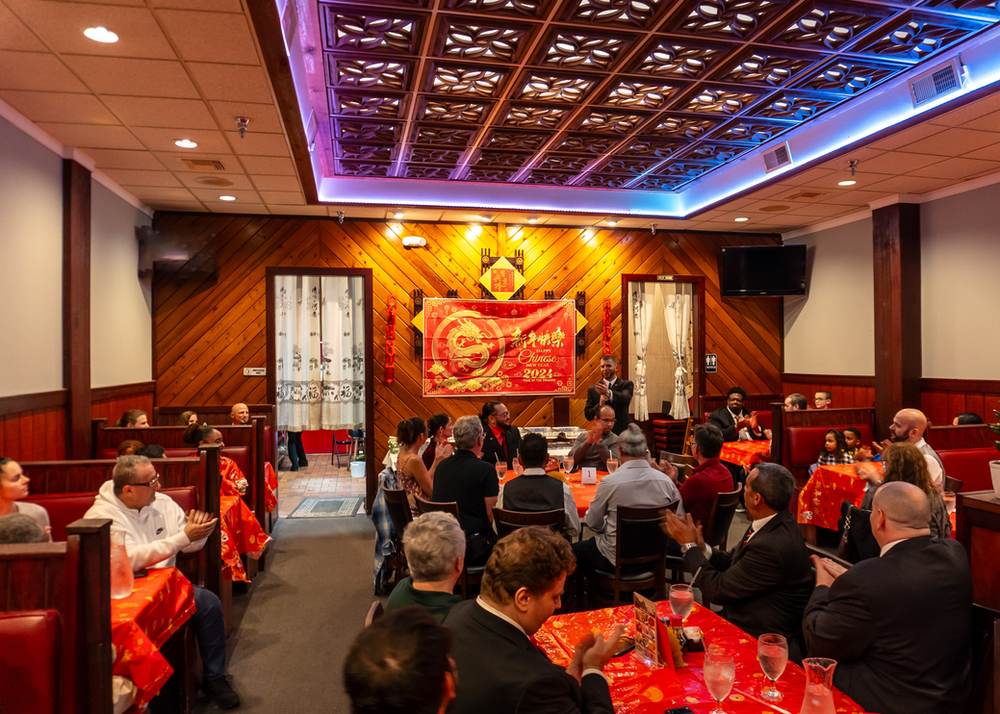 A group of people are sitting at tables in a restaurant.