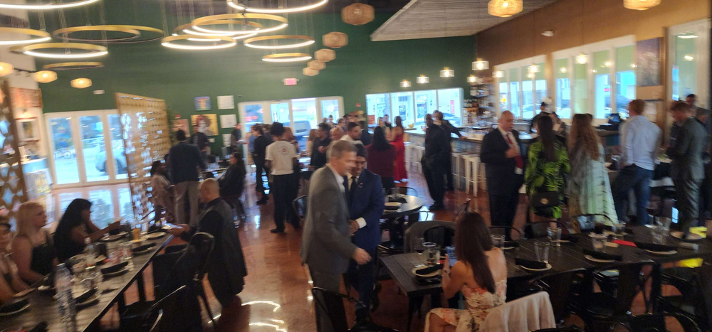 A large group of people are sitting at tables in a restaurant.