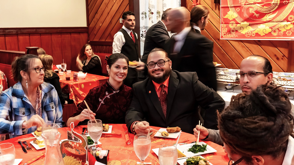 A group of people are sitting at a table in a restaurant eating food.