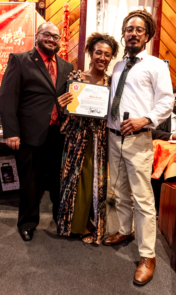 Two men and a woman are standing next to each other holding a certificate.