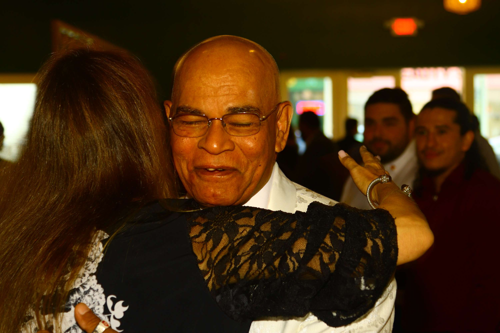 A man and woman are dancing together in a crowded room.