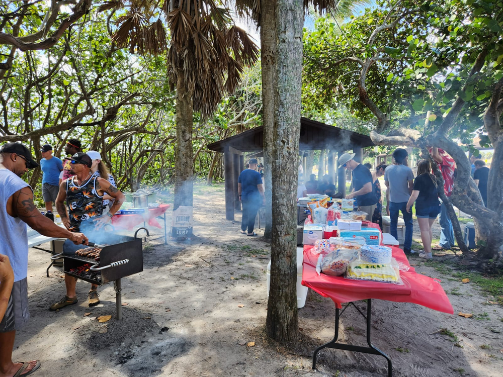 A group of people are having a picnic in the woods.