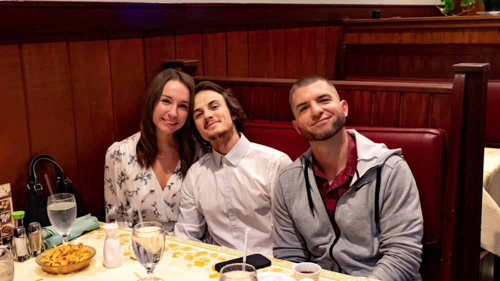 Three people are sitting at a table in a restaurant.