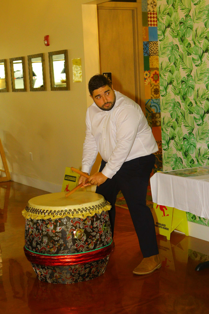 A man is playing a drum in a room.