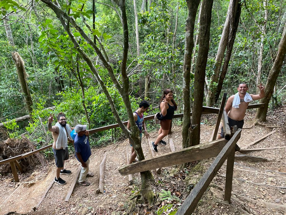 A group of people are walking down a path in the woods.