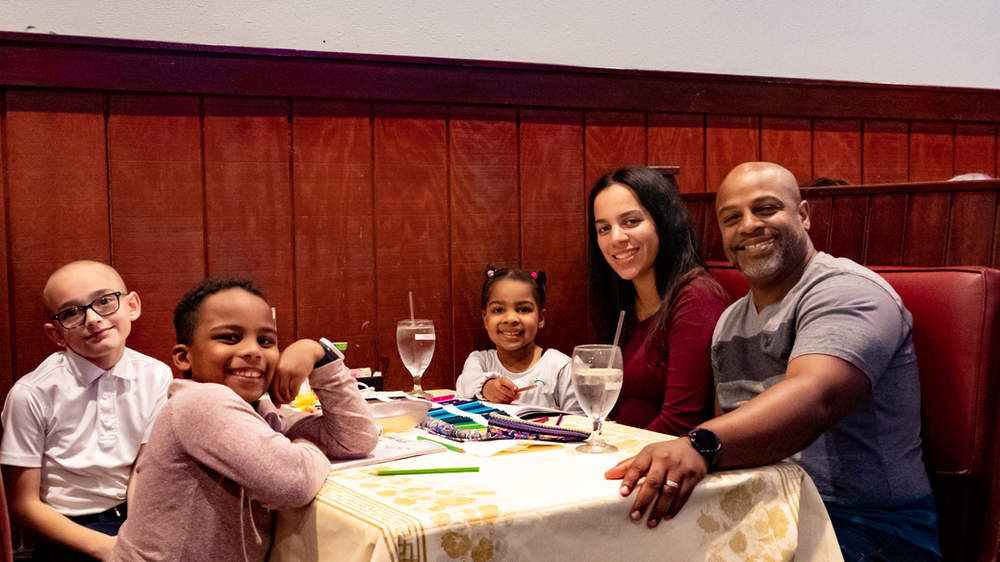 A family is sitting at a table in a restaurant.