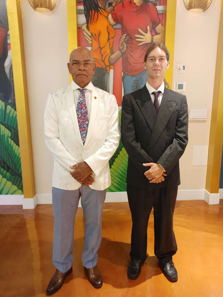 Two men standing next to each other in front of a painting