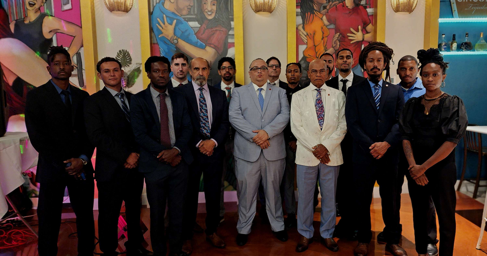 A group of people in suits and ties are posing for a picture.