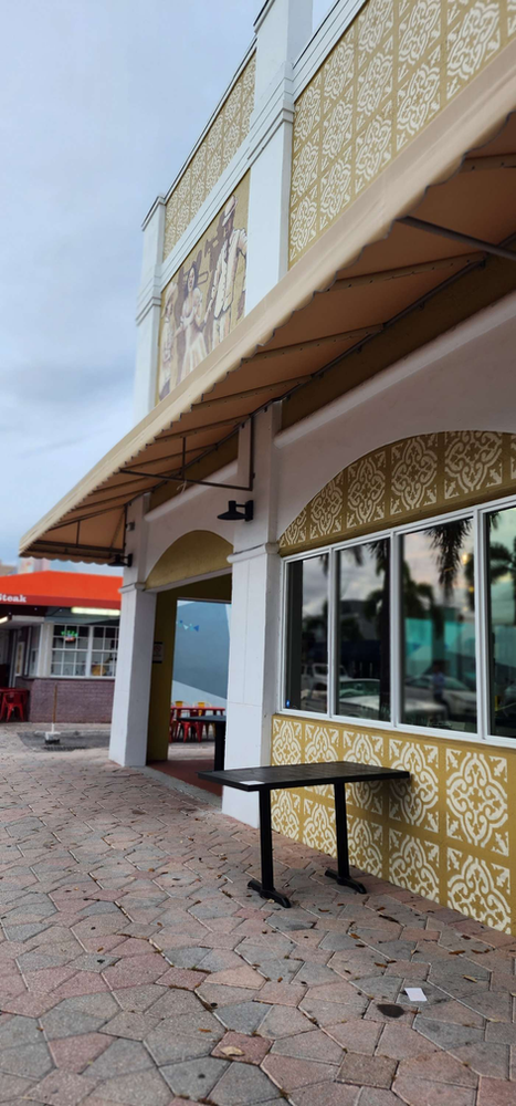 A building with a canopy over it and a table in front of it.