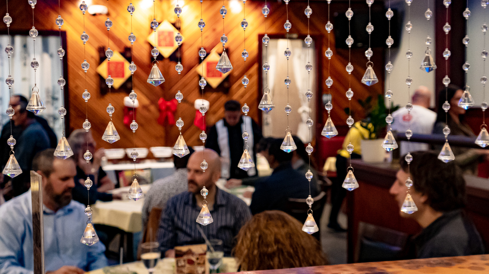 A group of people are sitting at tables in a restaurant.