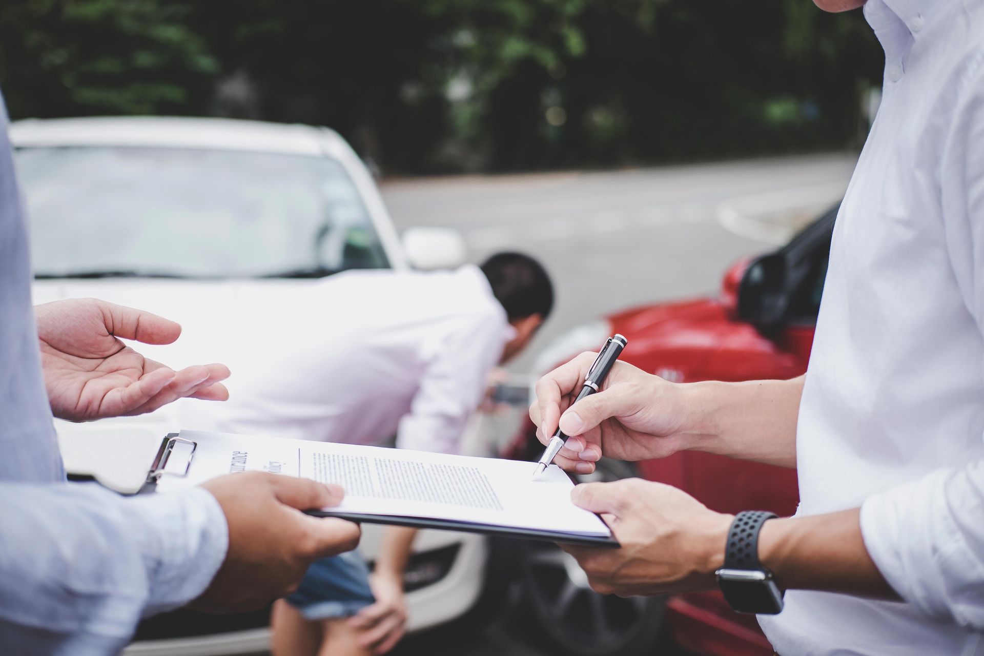 Two damaged cars with people checking the scene and completing the report. Two damaged cars with people checking the scene and completing the report.