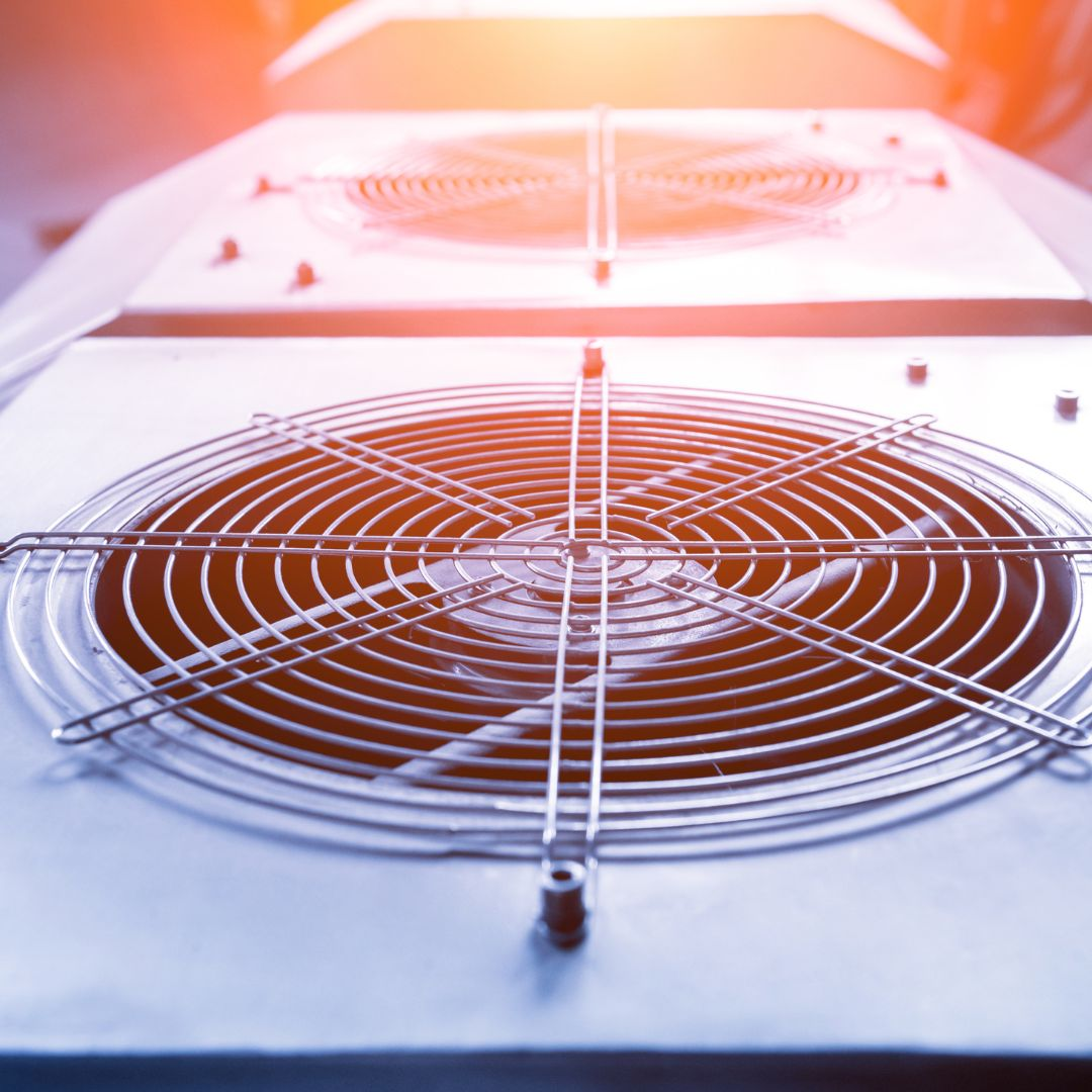 Industrial fan with protective metal grill, cooling system component.