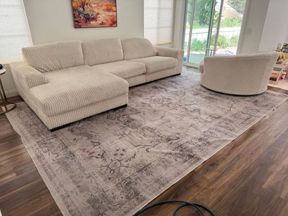 Bright living room with cream sectional sofa, matching chair, large gray rug, and sliding glass doors