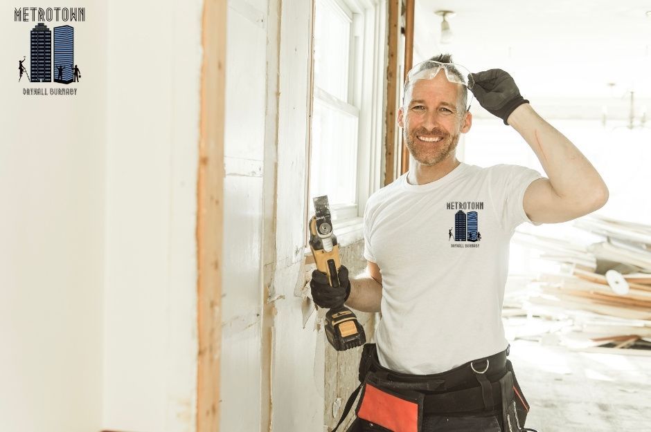 A confident drywall repair handyman is holding a drilling tool during a commercial drywall installation project. The drywall project is near 134a St and 64 Ave in Surrey, BC.