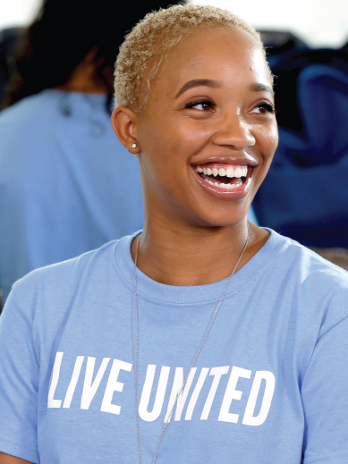 a woman wearing a blue shirt that says live united