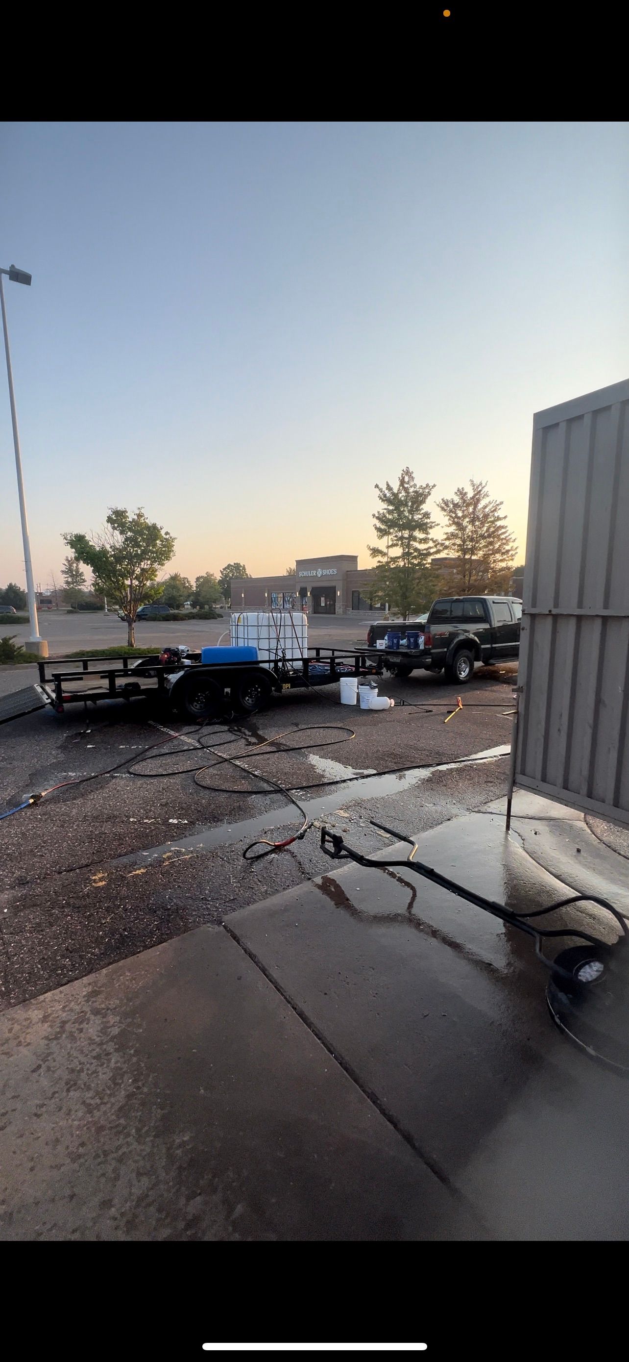 A trailer is sitting in a parking lot next to a building.