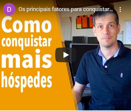 A man sitting in front of a computer with the words como conquistar mais hospedes