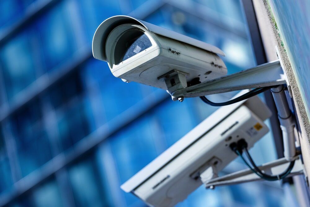 Two Security Cameras Are Mounted on the Side of a Building — Audiomation in Taree, NSW