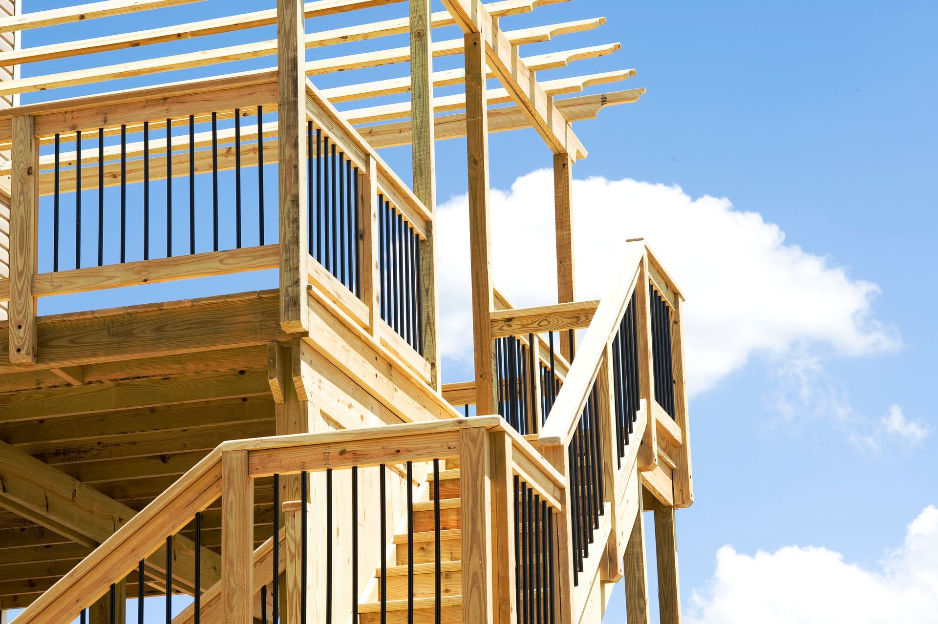 A wooden deck is being built with a blue sky in the background.